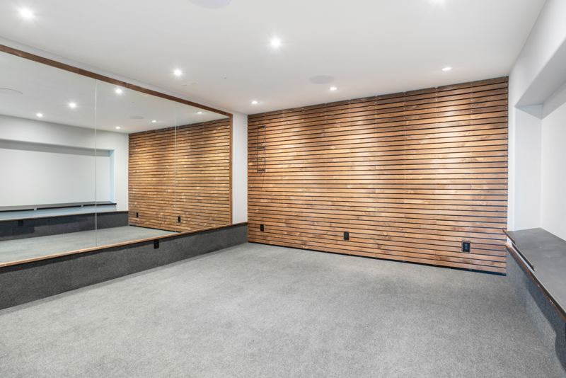 Fitness room with mirrored and wood-slat walls