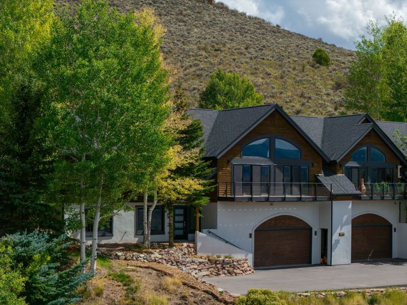 Exterior with aspens, stone accents and two-car garage