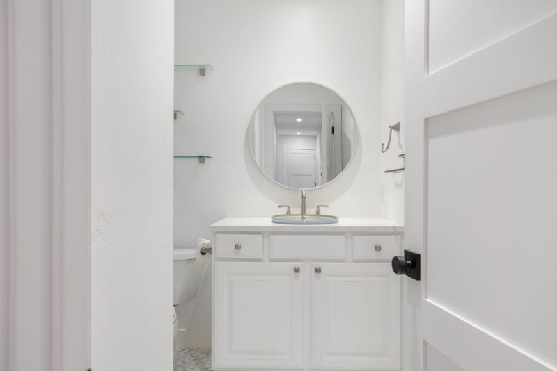 Bathroom with round mirror and white vanity