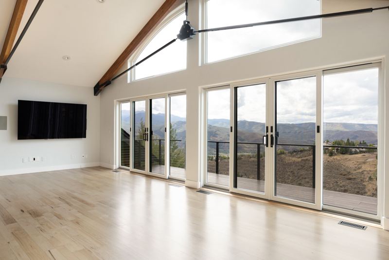 Great room with vaulted beams and walls of glass to the mountains