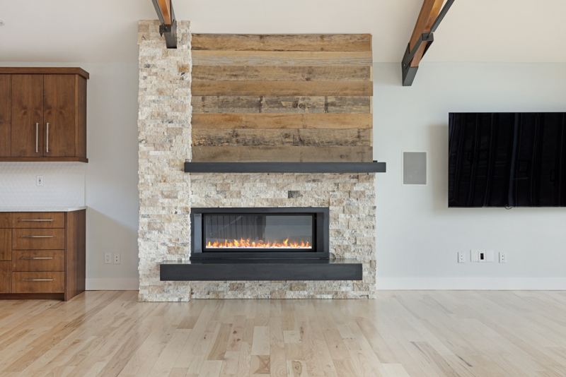 Fireplace detail with stacked stone and wood surround
